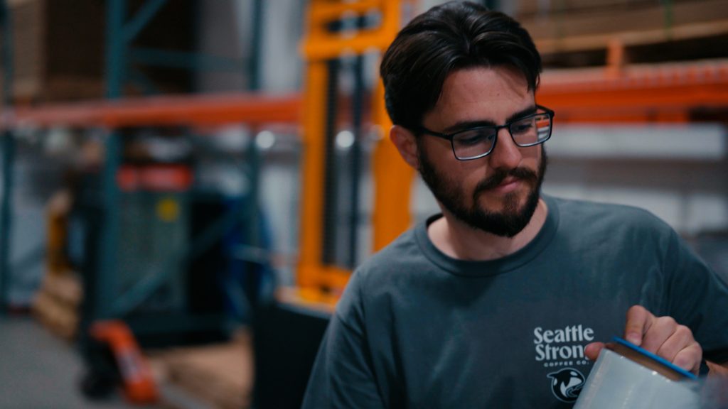 Man wrapping a pallet of cold brew coffee cans