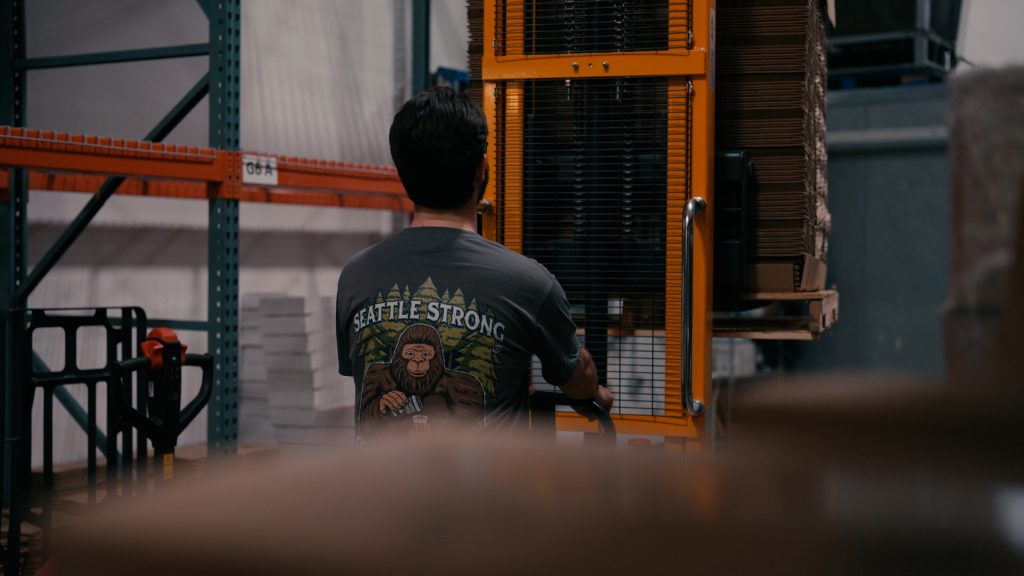 Man in warehouse operating forklift