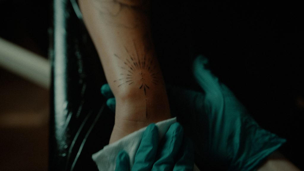 Tattoo artist wiping a tattoo while working on it